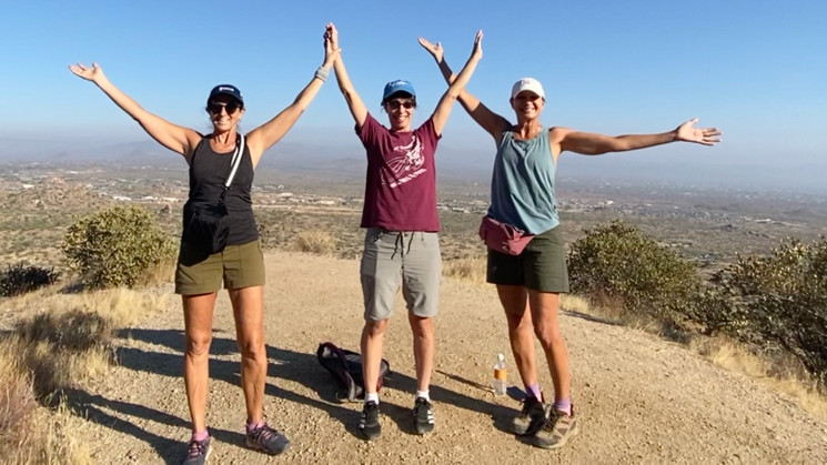 Three people at the top of a mountain